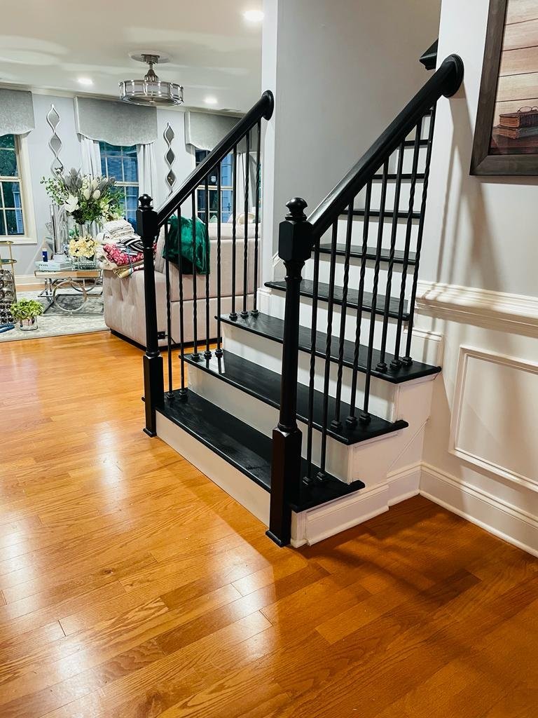 Staircase with black treads, white risers and iron balusters