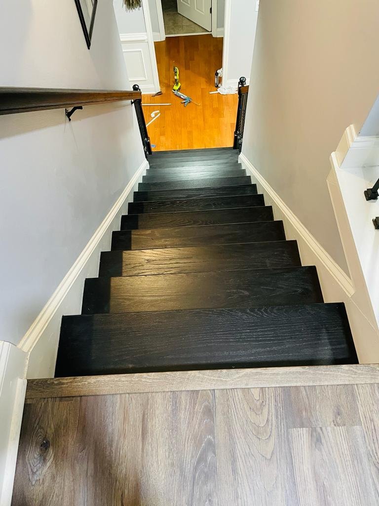 Dark stained hardwood staircase with white trim