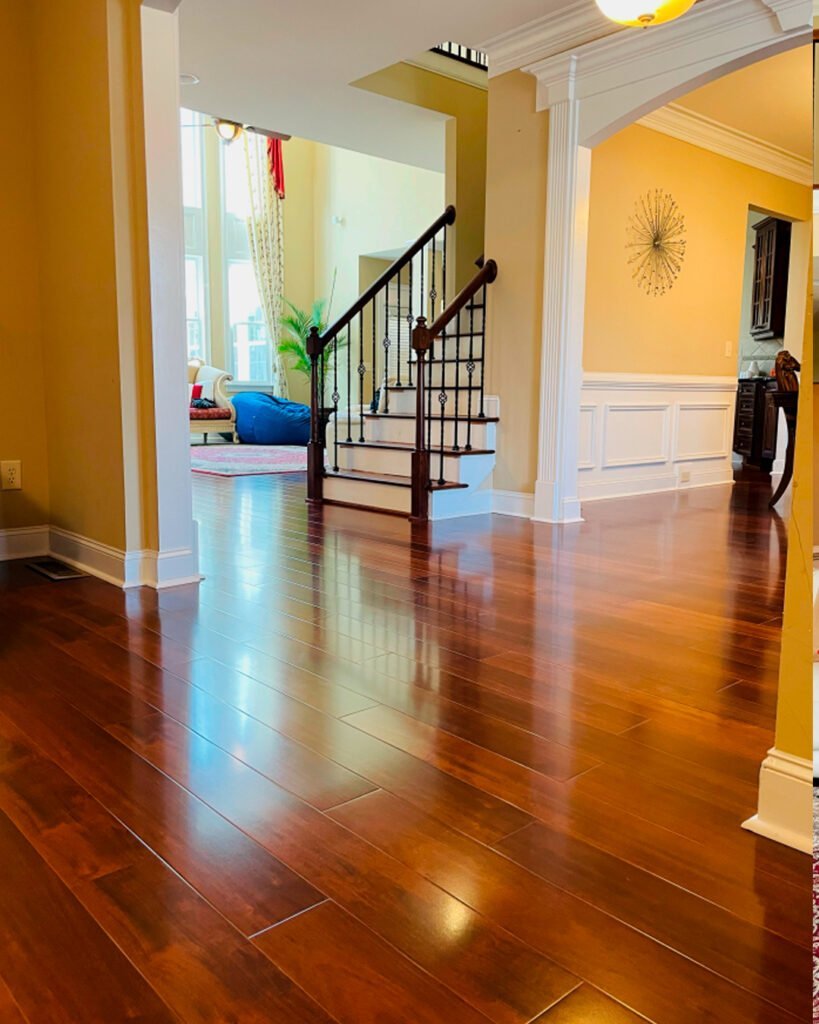 Hardwood floor in an entry hall with a staircase and iron railing