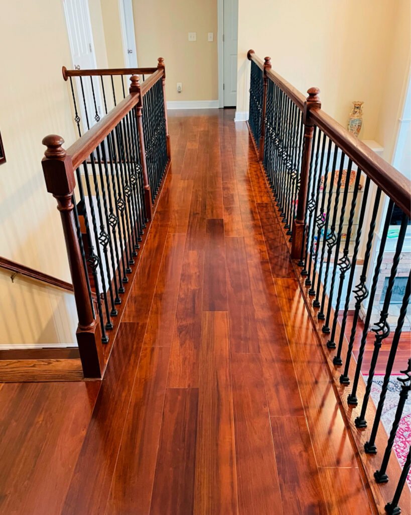 Hardwood upstairs hall with iron balusters and a wood handrail