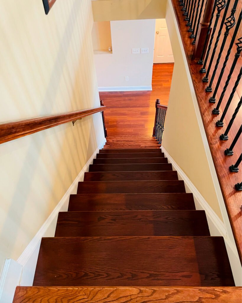Stained wood staircase seen from above with a wood handrail